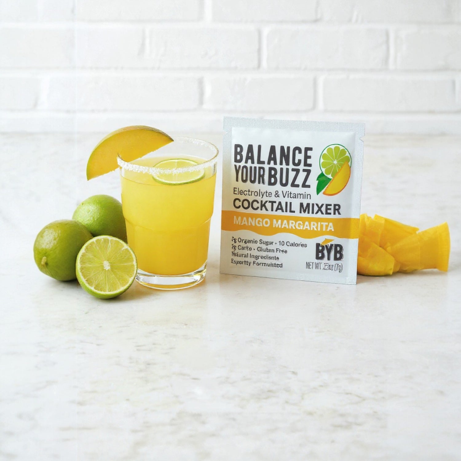 Balance Your Buzz cocktail mixer package with a glass of mango margarita and ingredients on a white surface.